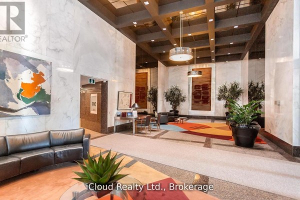 Building lobby with marble walls, seating areas, artwork, and potted plants. - 837 - 33 Harbour Square, Toronto