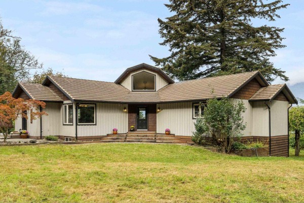 Exterior view of a single-story house with a large front lawn. - 8379 Chelmsford Place, Chilliwack Mountain, Chilliwack