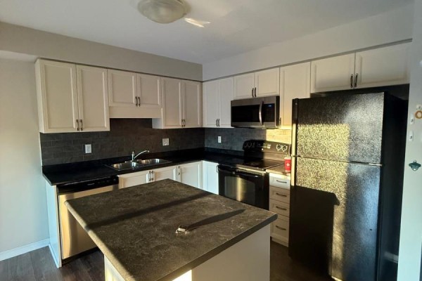 Kitchen with white cabinets, black countertops, stainless steel appliances, and a dark island. - 84 - 355 Fisher Mills Road W, Cambridge