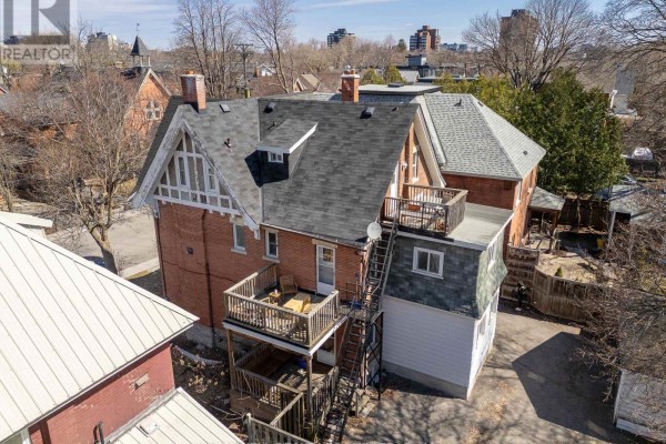 White kitchen with light wood floors, white cabinets, stove, and dishwasher. - 84 Fourth Avenue, Ottawa