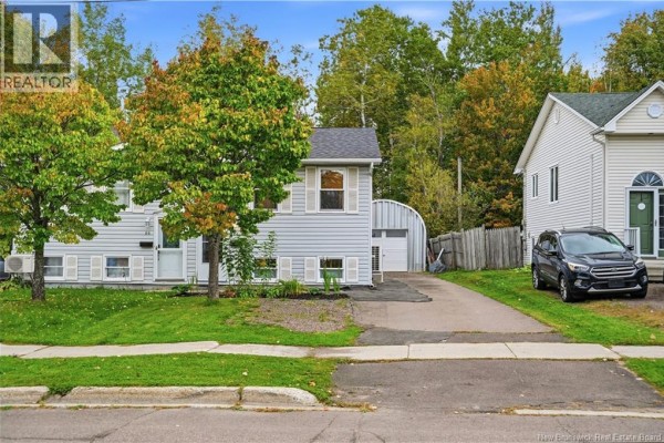 Front view of the house with a driveway and a detached garage. - 84 Glencoe Drive, Moncton