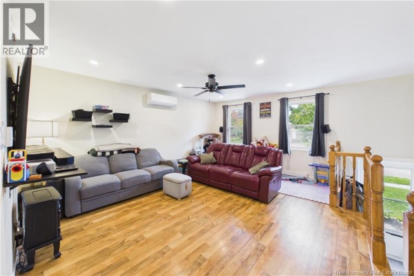 Living room with two sofas, a ceiling fan, and hardwood floors. - 84 Glencoe Drive, Moncton