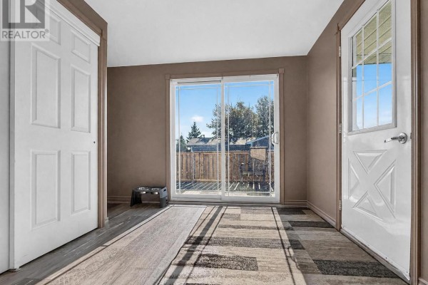 Hallway with sliding glass door, entry door, dog bowls and wood-look flooring - 84 Highway 11 Highway E Hearst