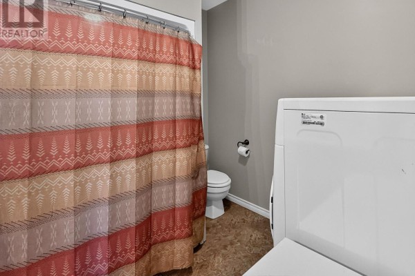 Bathroom with toilet, washer, dryer, and patterned shower curtain - 84 Highway 11 Highway E Hearst