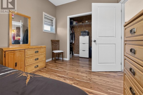 Bedroom with dresser, chair, closet, and wood-look flooring - 84 Highway 11 Highway E Hearst