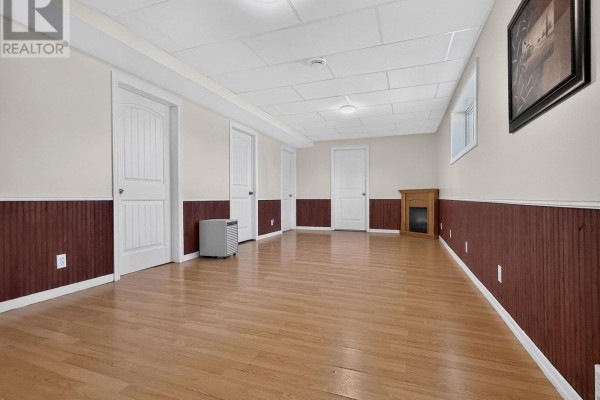 Finished basement with wood floors, fireplace mantel, and multiple doors - 84 Highway 11 Highway E Hearst