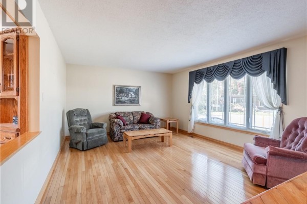 Living room with hardwood floors, neutral walls, and a large bay window. - 84 Neelon Avenue, Sudbury