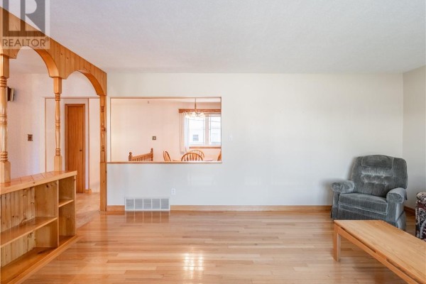 Living room with hardwood floors, pass-through to dining area, and wood trim. - 84 Neelon Avenue, Sudbury