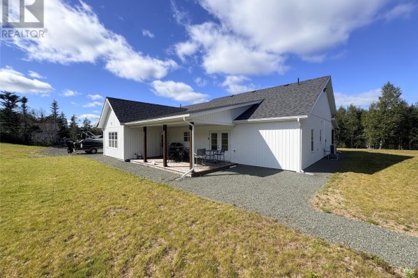 Rear view of white house with a covered patio area and doors leading outside. - 84 Road To The Isles Road, Lewisporte