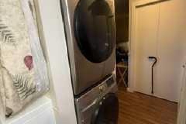 Stacked stainless steel washer and dryer in an apartment. - 8412, 304 Mackenzie Way Sw, Airdrie