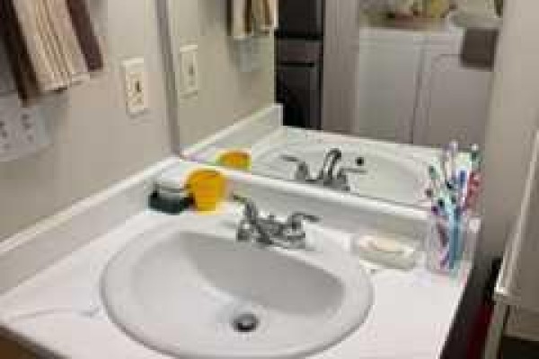 Apartment bathroom vanity with white sink, faucet, and mirror. - 8412, 304 Mackenzie Way Sw, Airdrie