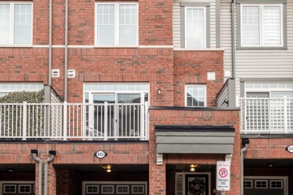 Exterior view of a brick townhouse with white windows and balconies.  - 842 Atwater Path, Oshawa