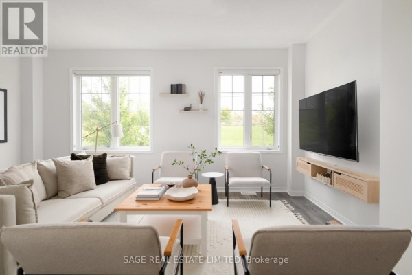 Living room with two windows, white seating, a coffee table, and a television on the wall. - 842 Atwater Path, Oshawa