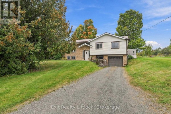A split-level house with a gravel driveway, green lawn, and trees. - 842 Chemongview Drive, Selwyn