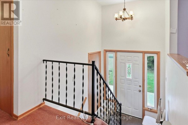 Interior view of the entryway with a staircase, white door, and chandelier. - 842 Chemongview Drive, Selwyn