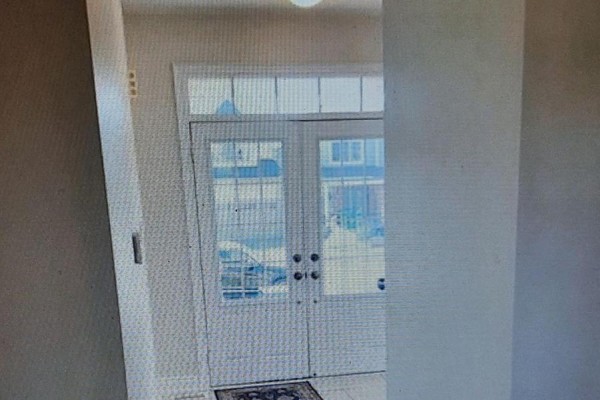 Front entrance with double glass doors and transom windows, viewed from inside the house. - 8421 Sweet Chestnut Drive, Niagara Falls