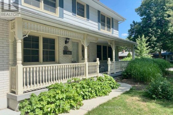 Close-up view of the white wood railing and decorative posts on the covered front porch of the house. - 843 Driftwood Road, London North