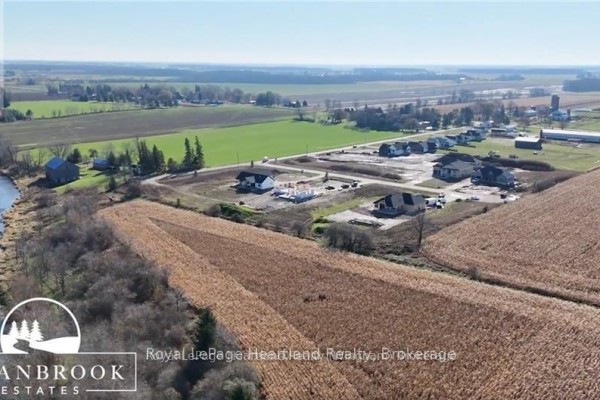 Aerial view of the neighborhood with farmland and new developments in the background. - 84347 Kent Line, Huron East