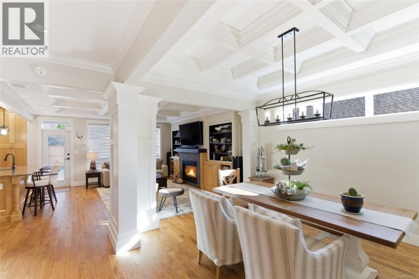Open-concept dining and living area with a coffered ceiling, fireplace, and island view. - 844 Mulholland Dr, French Creek