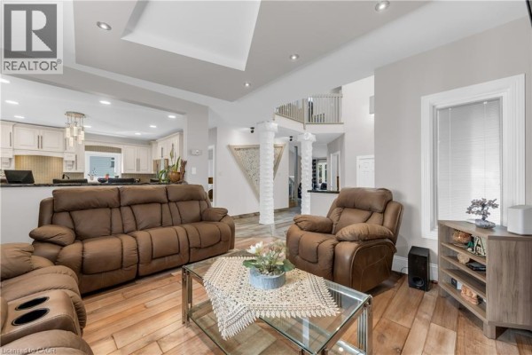 Interior entryway with a high ceiling, white double doors, tiled floor, and view of the living room. - 847 West 5th Street, Hamilton