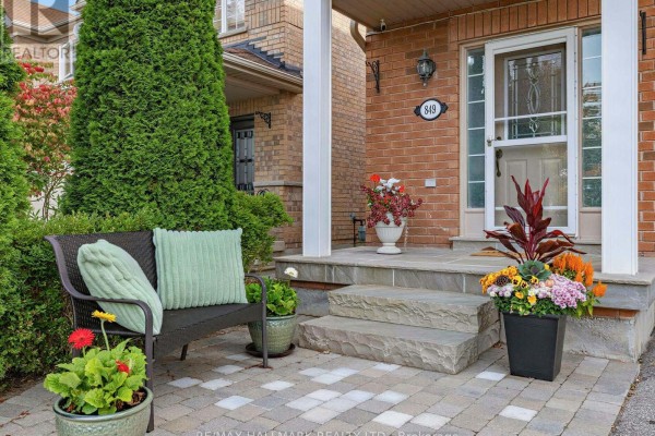 Front porch with stone steps, seating, and potted plants. - 849 Joe Persechini Drive, Newmarket
