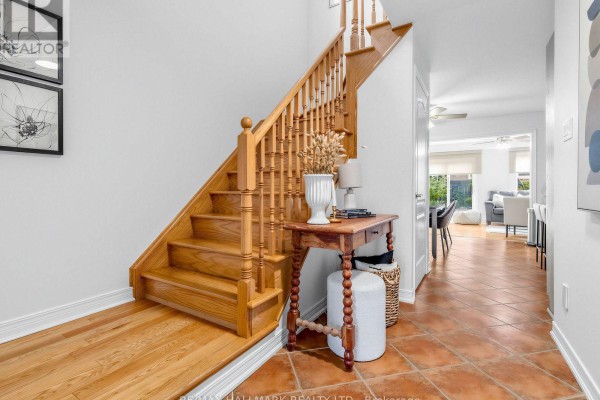 Hallway featuring a wooden staircase, console table, and terracotta tile flooring. - 849 Joe Persechini Drive, Newmarket