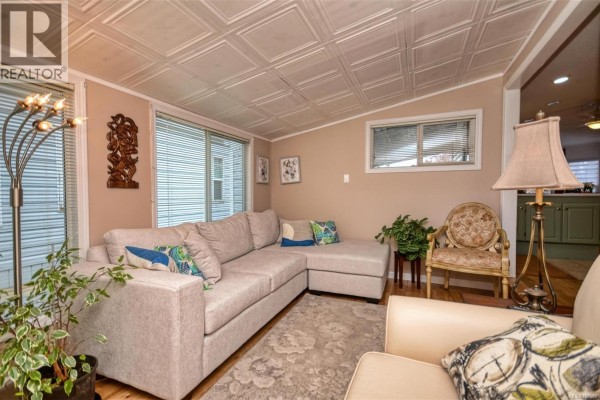 Cozy seating area with large sectional sofa and decorative plants - 85 7583 Central Saanich Rd, Central Saanich