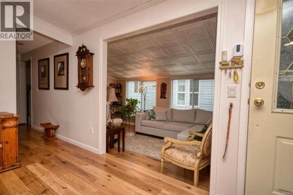 Entryway with hardwood flooring and views into the living room - 85 7583 Central Saanich Rd, Central Saanich