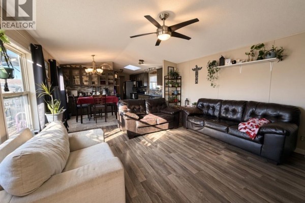 Living room with a large sectional sofa, a leather couch, and wood-look flooring. - #85 9824 104 Avenue, Clairmont