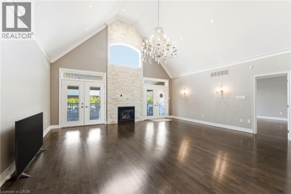 Basement utility area with black fridge, white oven, furnace, and storage shelves - 85 Hillcroft Drive Stoney Creek