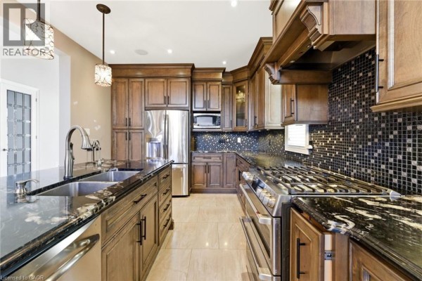 Luxury home with stone facade, arched entryway, and double garage - 57 Hillcroft Drive Stoney Creek