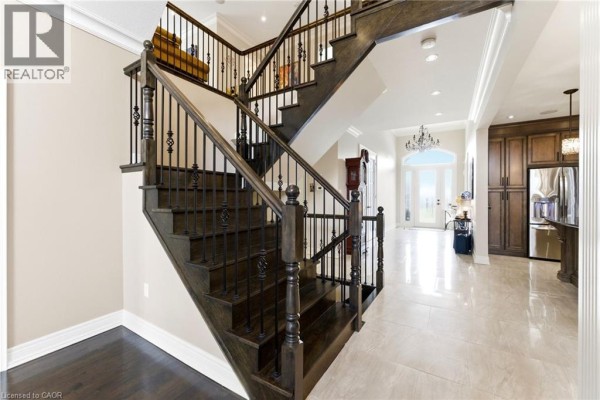 Luxury home with stone facade, arched entryway, and double garage doors - 85 Hillcroft Drive Stoney Creek