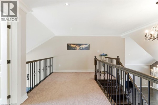Hallway with staircase, blue sofa, and bathroom entrance - 85 Hillcroft Drive Stoney Creek