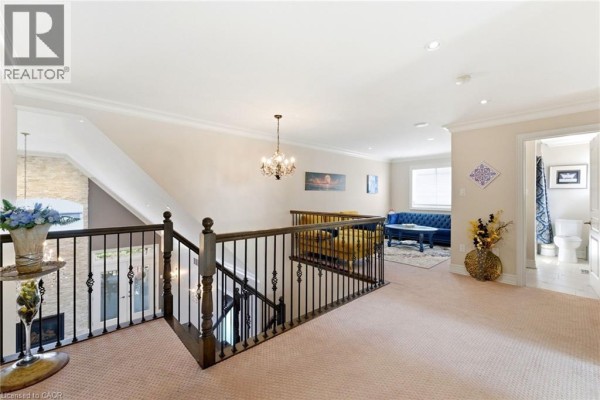 Living room with vaulted ceiling, stone fireplace, chandelier, and hardwood floors - 85 Hillcroft Drive Stoney Creek