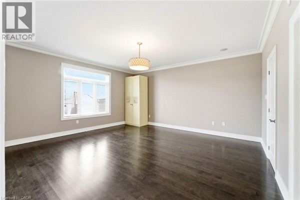 Modern kitchen with granite island and double oven gas range opens to living room with fireplace and vaulted ceilings - 85 Hillcroft Drive Stoney Creek