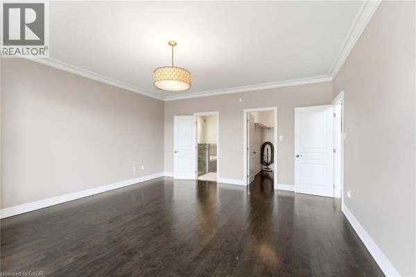 Unfinished basement with exposed beams, workbench, and storage shelves - 85 Hillcroft Drive Stoney Creek