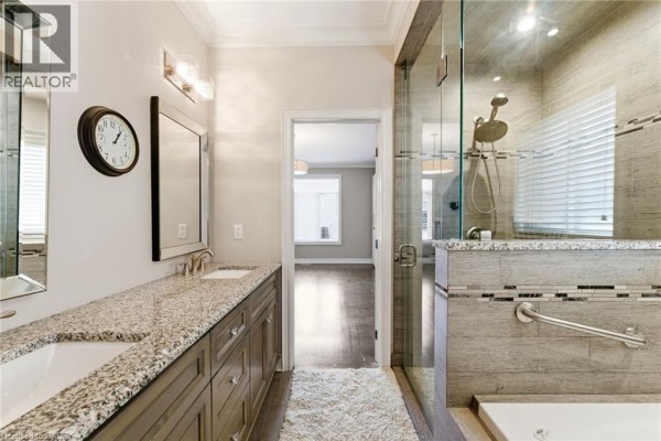 Gourmet kitchen with gas range, island, and vaulted ceiling living space with fireplace - 85 Hillcroft Drive Stoney Creek