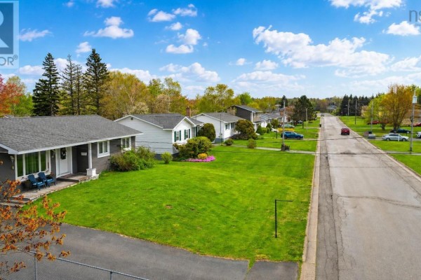 Street view of the neighborhood with houses, lawns, and a paved road under a partly cloudy sky. - 85 Ranni Crescent, Sydney