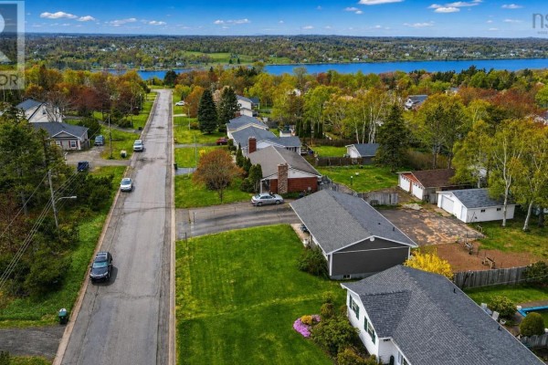 Aerial view of the residential street leading to a blue body of water in the distance. - 85 Ranni Crescent, Sydney