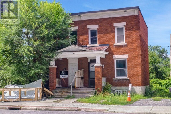 Two-story red brick building with a central porch entrance and white trim. - 85 Richmond Road, Ottawa