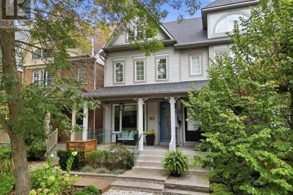 Close-up view of the facade of a light grey townhouse with a covered porch. - 85 Sarah Ashbridge Avenue, Toronto