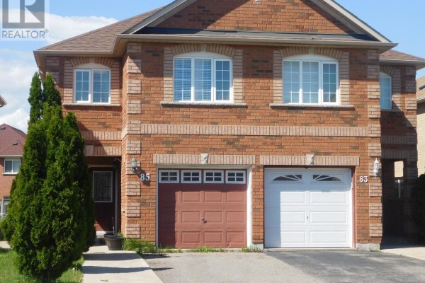 A two-story brick house with a double garage and manicured landscaping. - 85 Weather Vane Lane E, Brampton