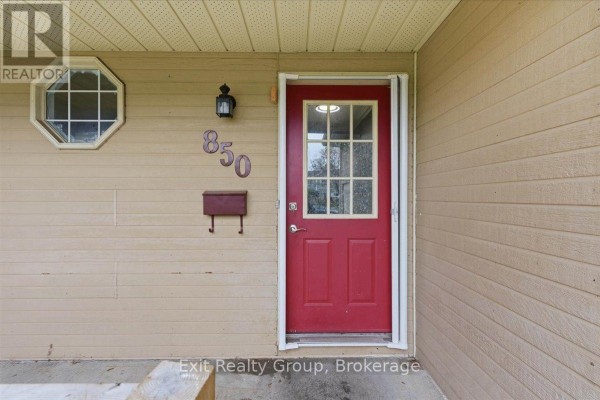 Close-up of the red front door with a glass pane and house number 850. - 850 Littlestone Crescent, Kingston