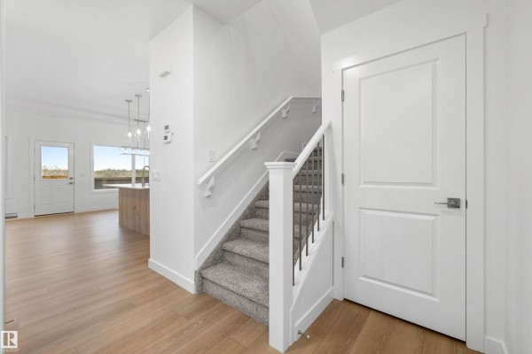 Interior hallway with two white doors and a small glass-paneled exterior door. - 8520 183 Av Nw, Edmonton