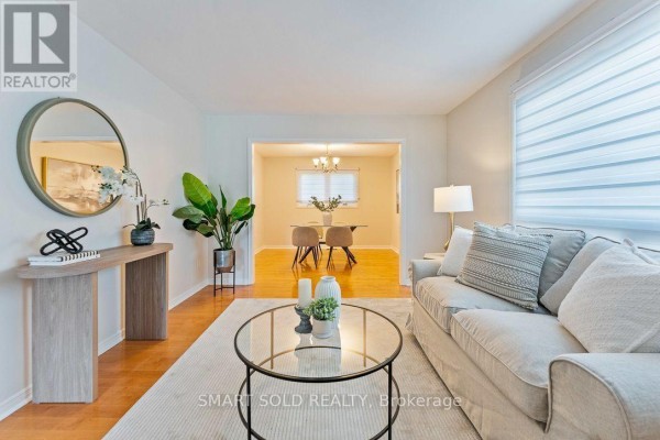 Living room with a sofa, coffee table, console table, and doorway to dining room. - 853 Apple Gate Court, Mississauga