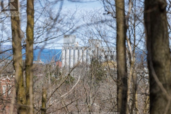 View of industrial grain elevators and water through bare tree branches, suggesting a distant view. - 855 4th Avenue A West Avenue, Owen Sound