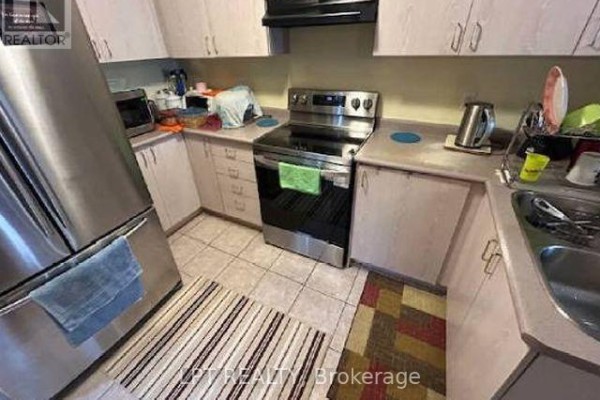 Kitchen with stainless steel refrigerator, stove, oven, light pink cabinets, and tiled flooring. - 8555 Martin Grove Road, Vaughan