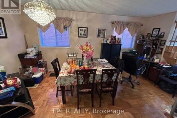 Dining room with a wooden table set for four, chairs, hardwood floors, and a chandelier. - 8555 Martin Grove Road, Vaughan