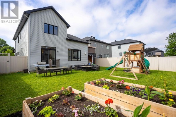Backyard with garden beds, playset, grill, and outdoor seating - 857 Cologne Street Russell