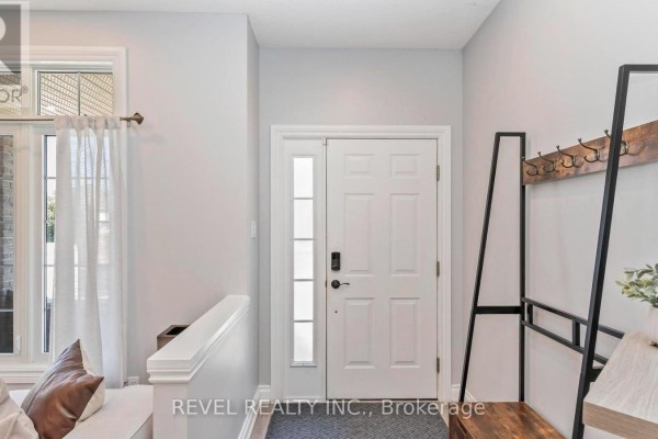 Interior entryway with a white door, glass sidelight, and coat rack with wooden bench. - 857 Cresthaven Crescent, London South
